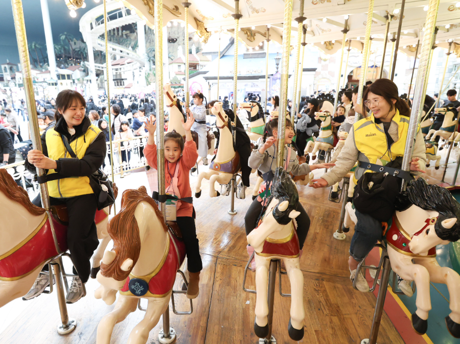 동서식품이 지난 26일 강원도 삼척시 도계 탄광마을 아동을 초청해 서울 송파구 롯데월드에서 문화 체험 프로그램을 함께 하는 임직원 봉사활동을 진행했다. 봉사활동에참여한 동서식품 임직원들이 아동과 놀이기구를 타고 있다.