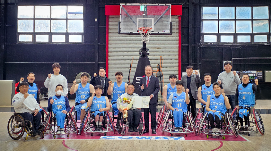 지난 5일 한국휠체어농구연맹 안병태 총재가 코웨이 블루휠스 연습구장을 찾아 김영무 감독에게 표창과 꽃다발을 전달했다. 안병태 총재와 김영무 감독, 코웨이 블루휠스 선수들이 함께 기념사진을 촬영하고 있다.