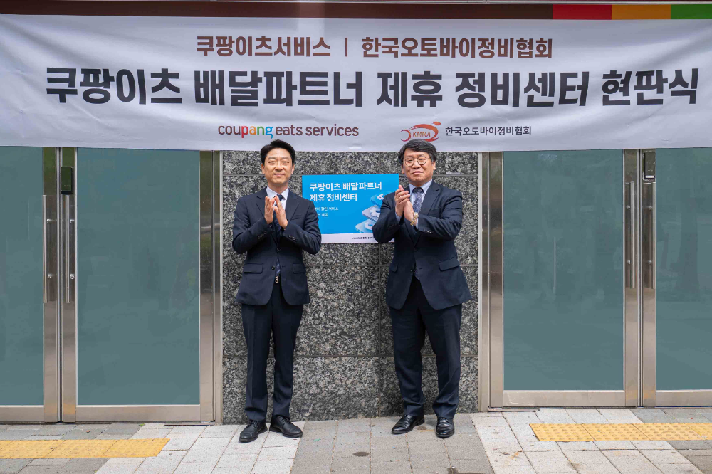 강동진 쿠팡이츠서비스 상무(왼쪽)와 이형석 한국오토바이정비협회 회장이 28일 서울 마포구 소재 쿠팡이츠서비스 제휴 정비센터에서 현판식을 기념하고 있다