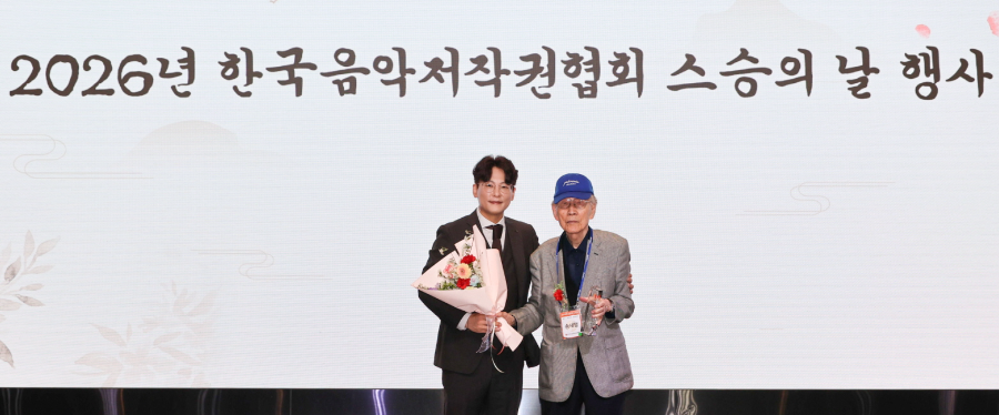 (▲이시하 음저협 회장(사진 왼쪽)이 송재철 회원(오른쪽)에게 감사패와 꽃다발을 전달한 뒤 기념촬영을 하고 있다)