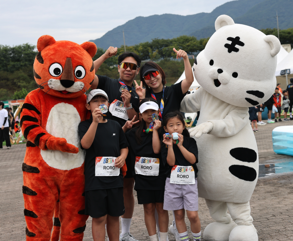 지난 12일 미사경정공원에서 열린 88run 마라톤 대회에서 완주에 성공한 한 가족 참가자들이 메달을 들어 보이며 기쁜 표정을 짓고 있다.