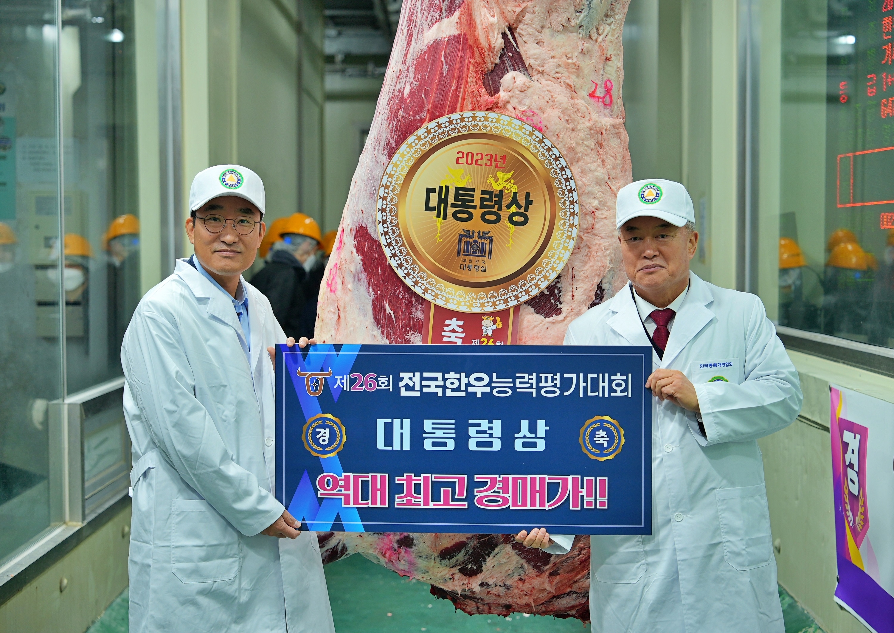 이영상 동원홈푸드 축육부문 대표(왼쪽)와 이재윤 한국종축개량협회 회장(오른쪽)이 지난 6일 충북 음성에서 열린 ‘제26회 전국한우능력평가대회’에서 대통령상 한우를 낙찰받고 기념 촬영을 하고 있다(사진=동원홈푸드제공)