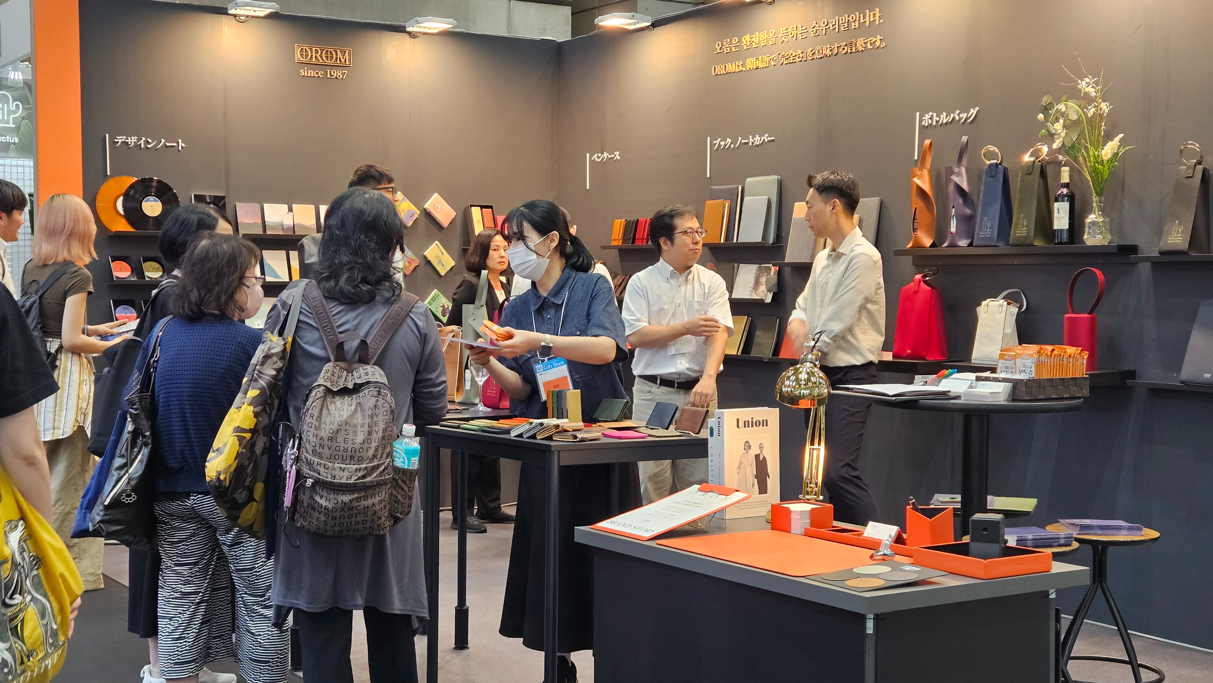오롬 부스를 방문한 관람객들이 제품에 대한 설명을 듣고 있다.