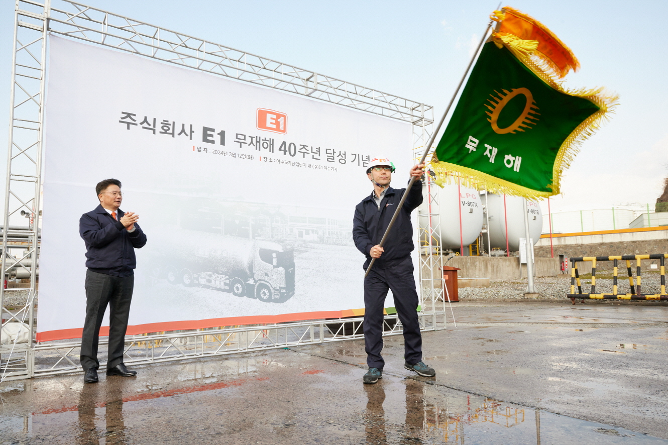 E1 김욱주 여수기지장(오른쪽)이 3월 12일 여수기지에서 무재해 40년 달성 기념 깃발을 흔들고 있다