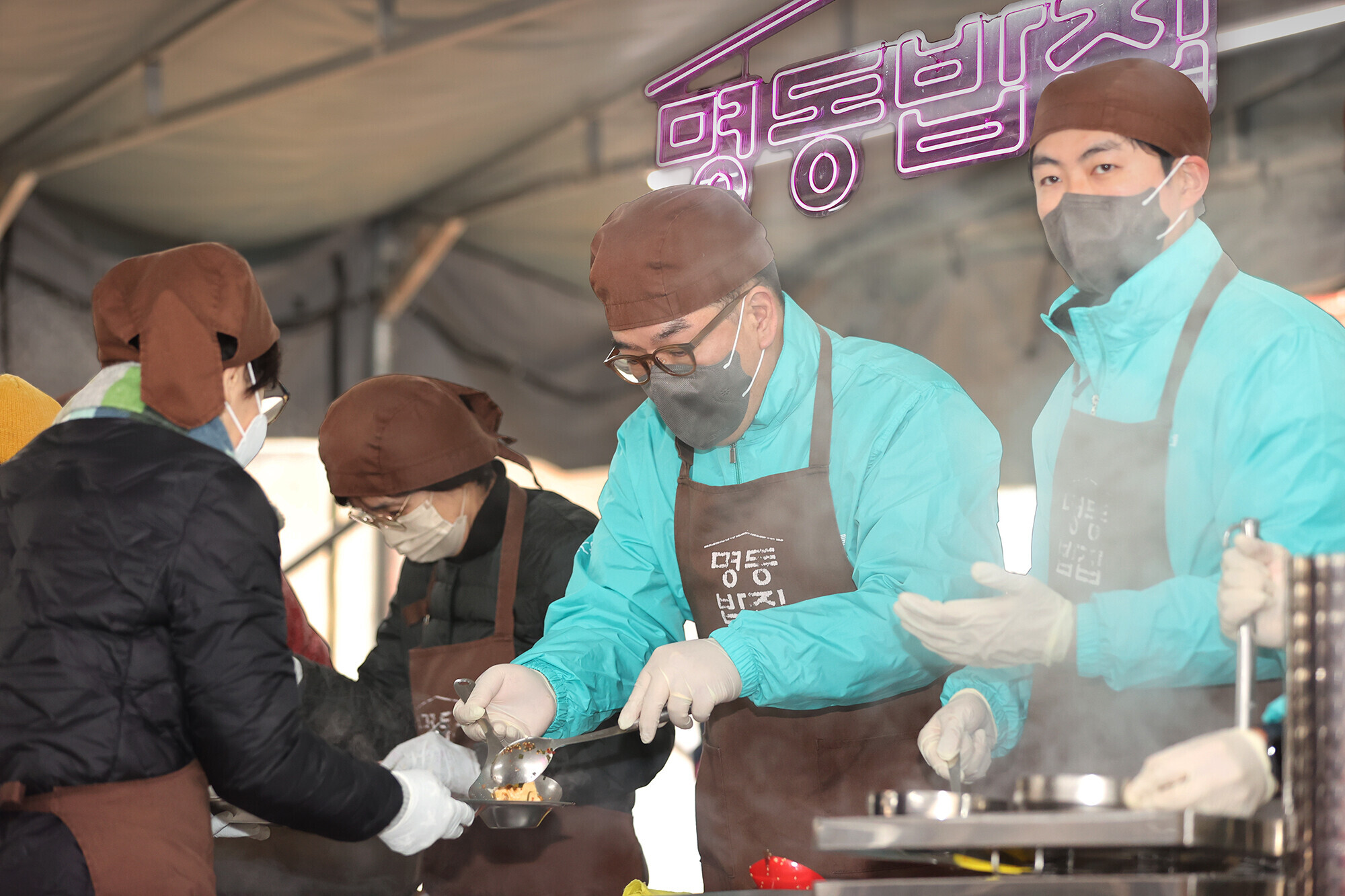 하나금융그룹은 지난 20일 서울 중구 명동대성당 영성센터에서 천주교 서울대교구 산하 한마음한몸운동본부(이사장 유경촌 주교)가 운영하는 무료급식소 '명동밥집'에 1,111그릇의 식사를 제공하고 임직원들이 함께 참여하는 봉사활동을 진행했다. 이날 봉사활동에 참석한 이은형 하나금융그룹 부회장(사진 가운데)이 봉사자들과 함께 식사 준비를 돕고 있다.