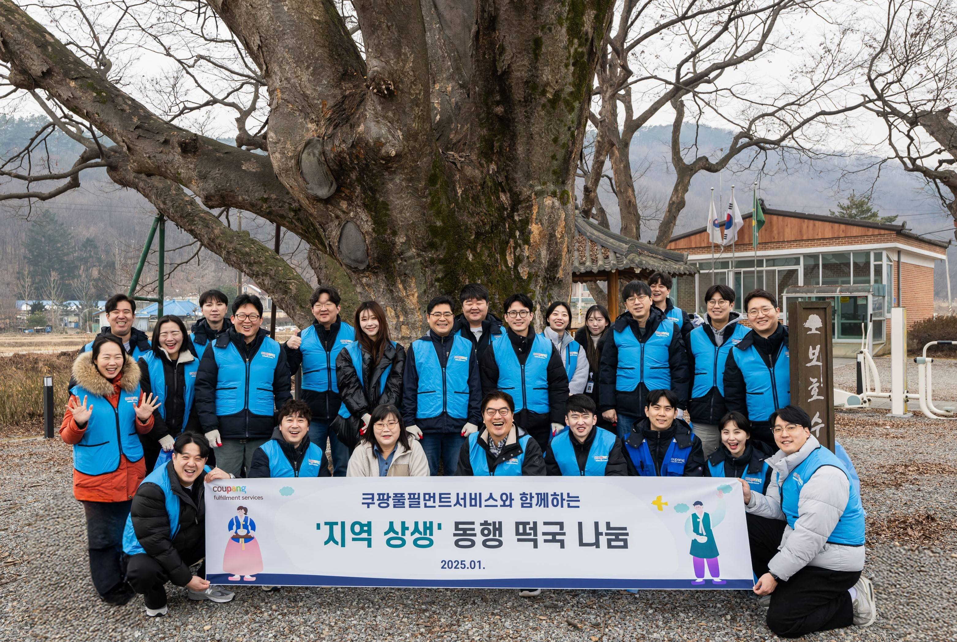 쿠팡풀필먼트서비스 임직원들이 경기도 용인시 처인구 남사읍 완장3리 마을회관 앞에서 ‘지역 상생 동행 떡국 나눔 기념 사진을 찍고 있다