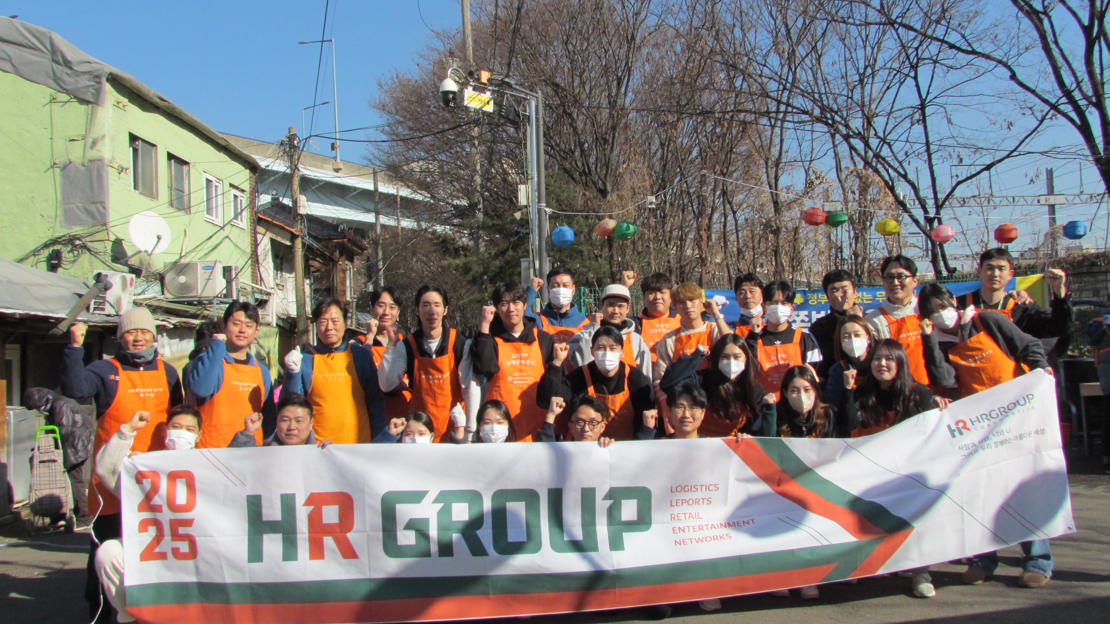 HR그룹(주) 임직원들과 배송기사들이 1월 23일 서울 영등포 쪽방촌에서 설날을 맞아 이웃들에게 따뜻한 떡국 나눔 봉사활동을 진행한 후 기념촬영을 하고 있다./HR그룹 미디어팀