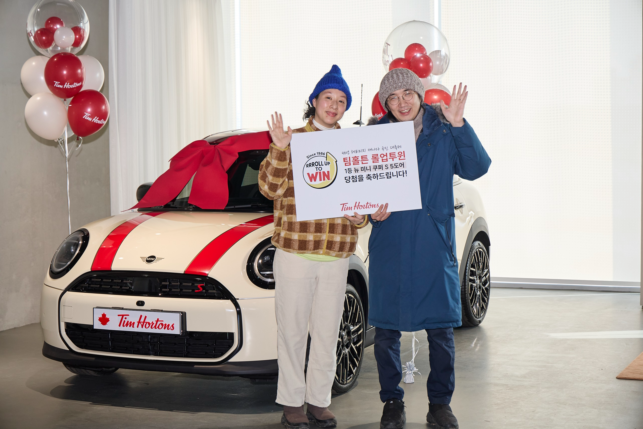 팀홀튼이 진행한 롤업투윈 캠페인의 1등 당첨자 가족이 BMW 뉴 미니 쿠퍼 S-5도어를 선물 받은 뒤 기념 촬영을 하고 있다.