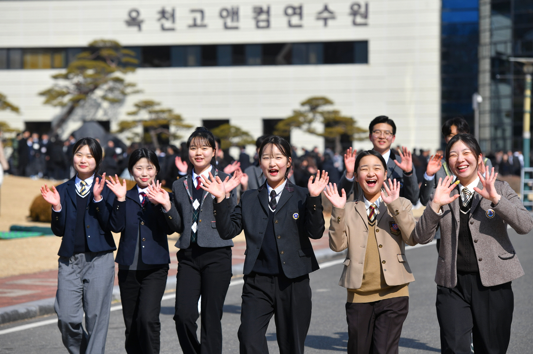 '2025 학생 개학예배'가 열린 하나님의 교회 옥천고앤컴연수원에서 학생들이 밝은 표정으로 손을 흔들고 있다.