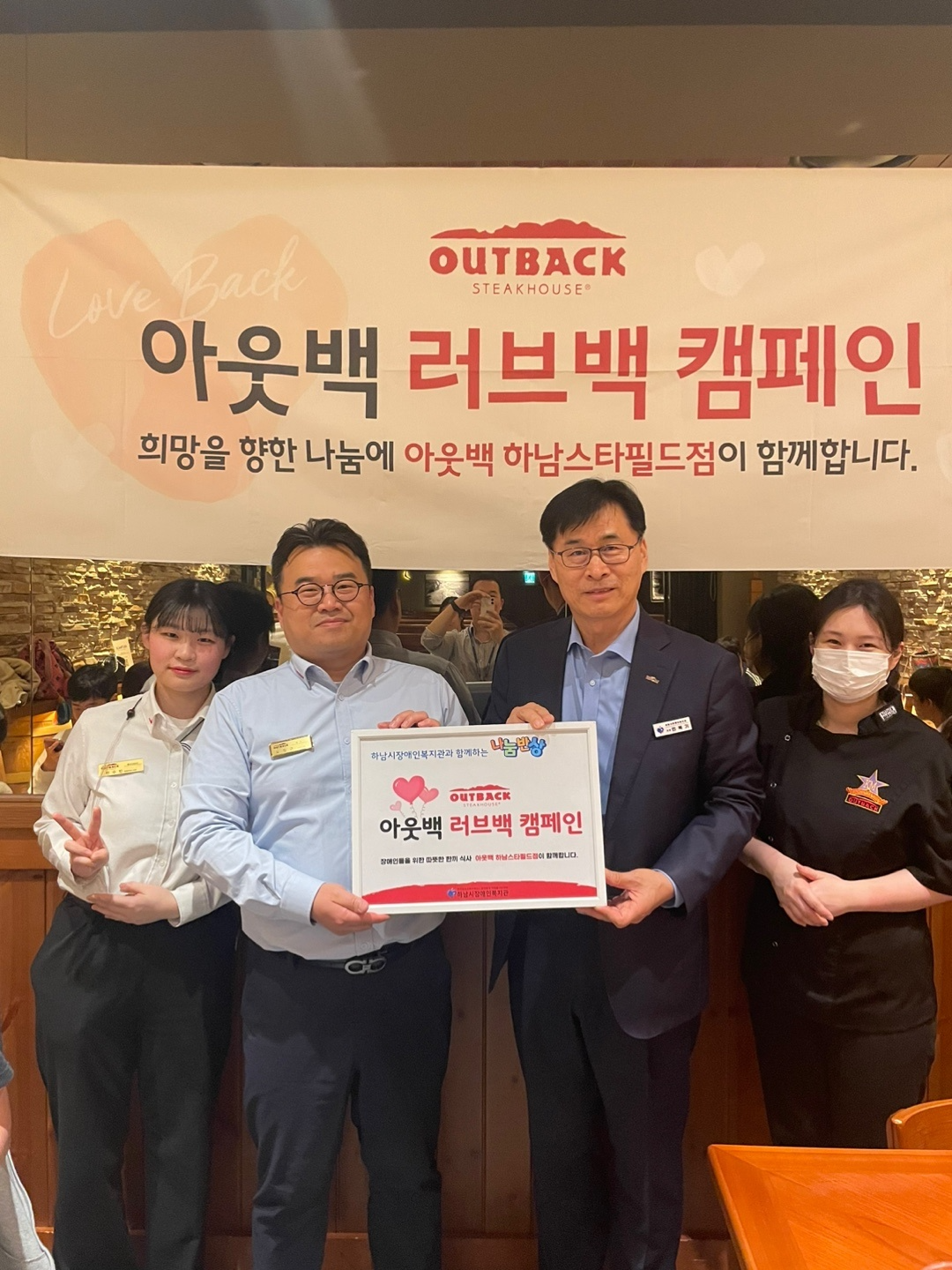 아웃백 하남 스타필드점 ‘러브백 캠페인’ 행사에서 (왼쪽부터) 한수빈 아웃백 하남 스타필드점 매니저, 오정근 아웃백 하남 스타필드점 점주, 민복기 하남시장애인복지관 관장, 이서우 아웃백 하남 스타필드점 매니저가 기념촬영을 하고 있다.