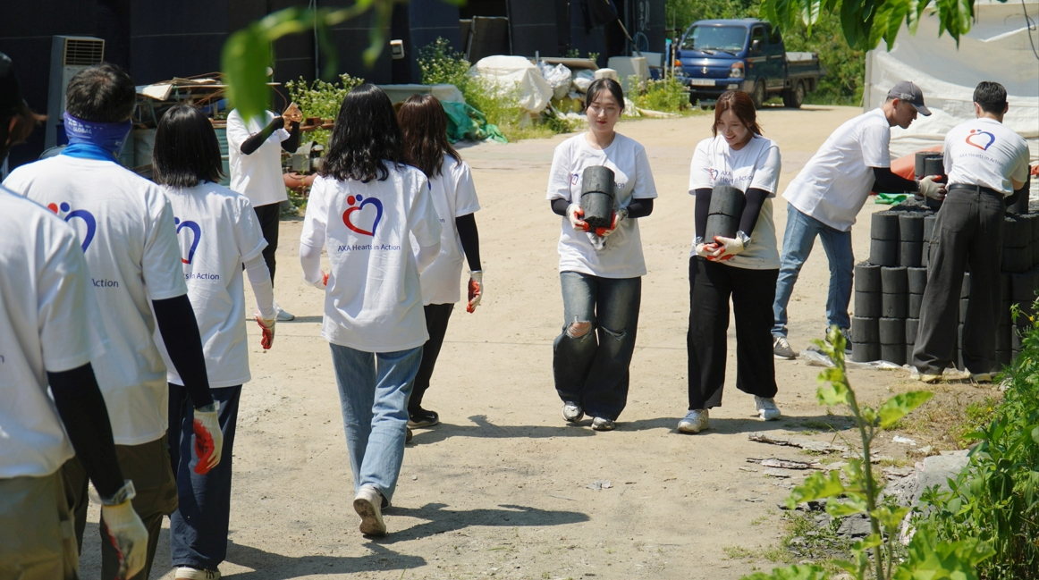 (AXA손해보험 임직원들이 연탄을 나르고 있다. 사진= 기부단체 희망조약돌)
