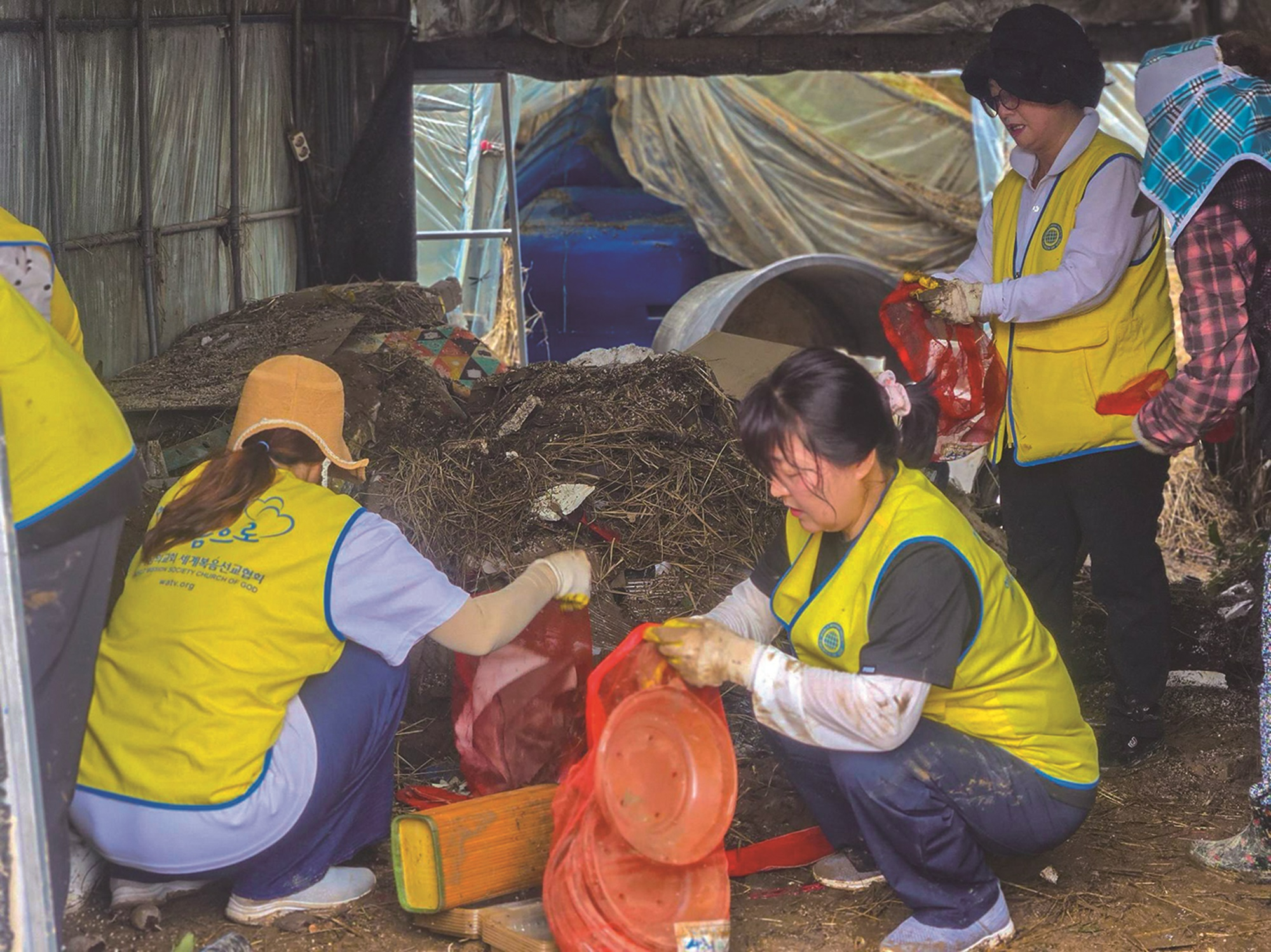 경남 합천의 농가를 찾은 하나님의 교회 신자들이 침수 피해로 못 쓰게 된 농기계 용품, 가재도구와 생필품 등을 치우며 정리를 돕고 있다.